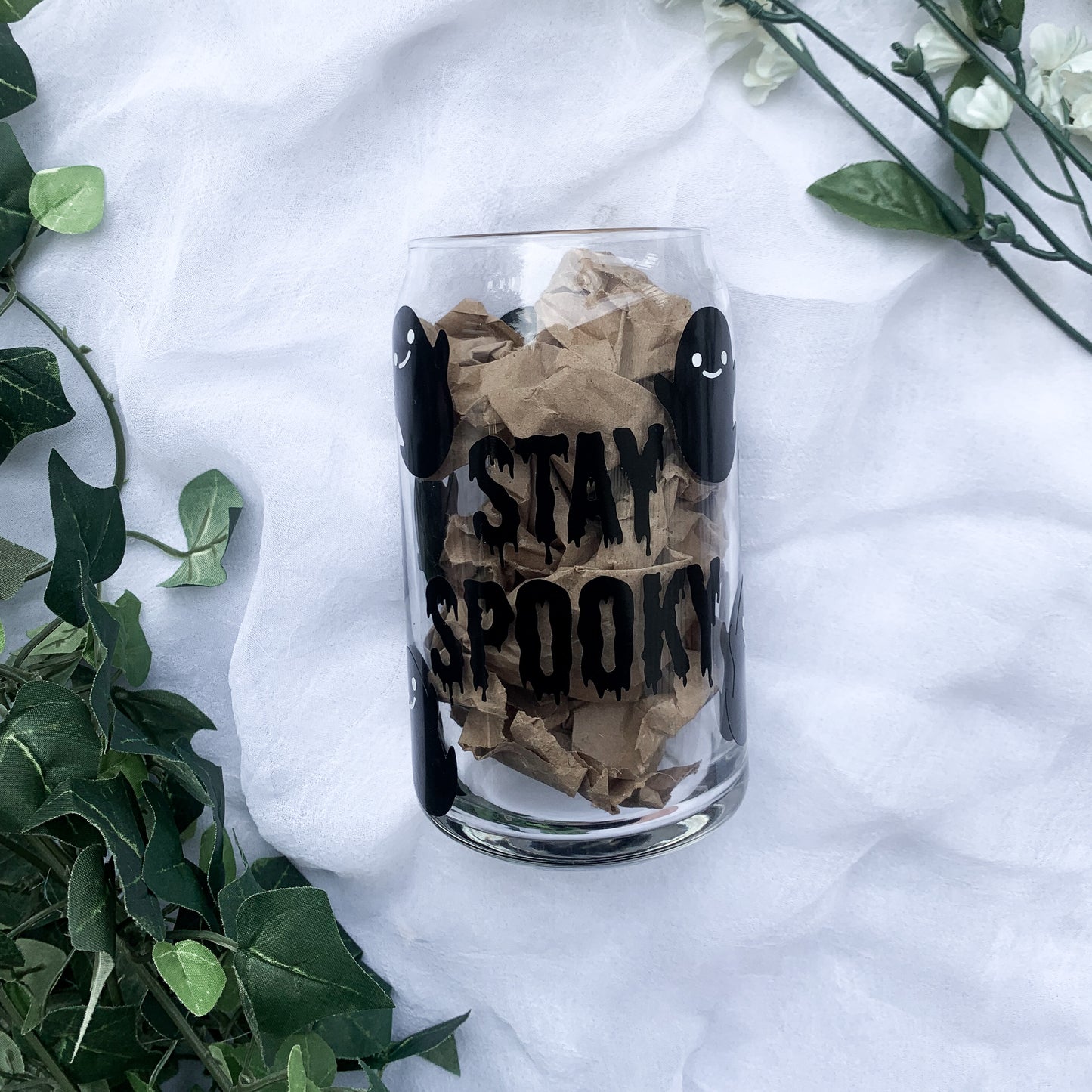 Halloween handmade drinkware featuring black ghosts with white eyes and smiley faces.
