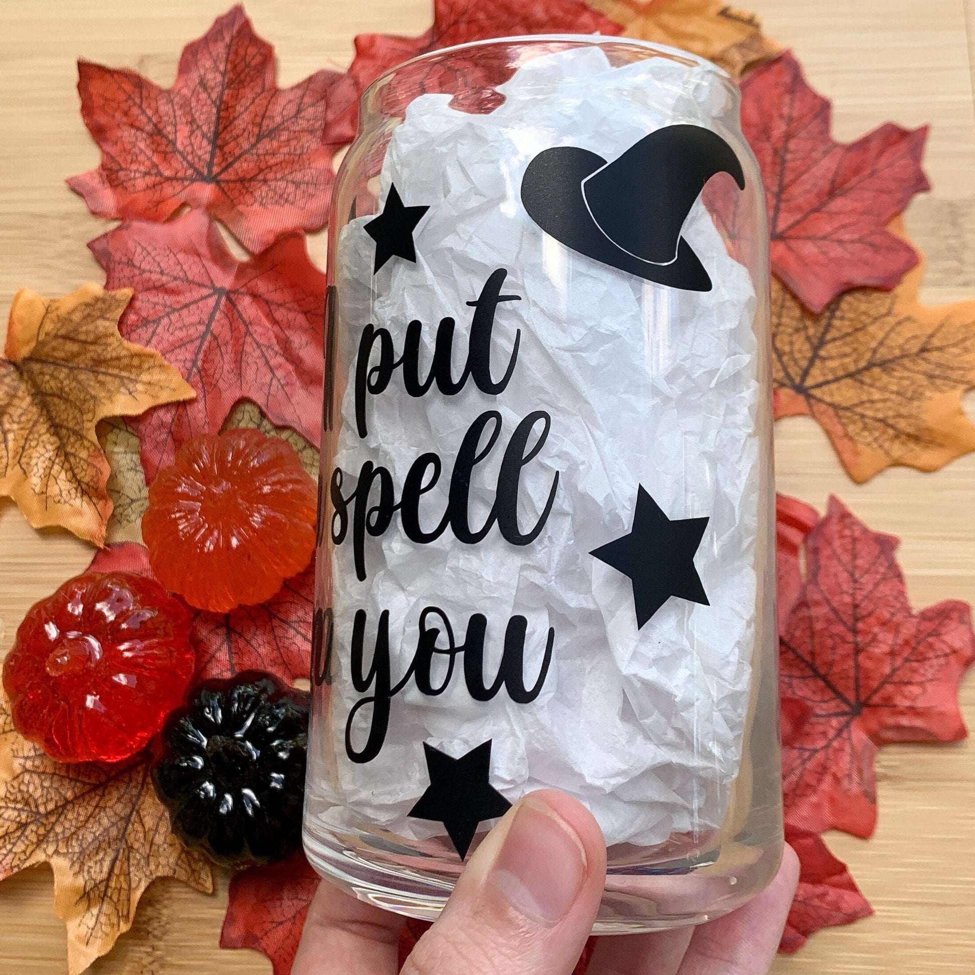Hand holding I put a spell on you glass cup and showcasing the witch's hat on the side of the cup.