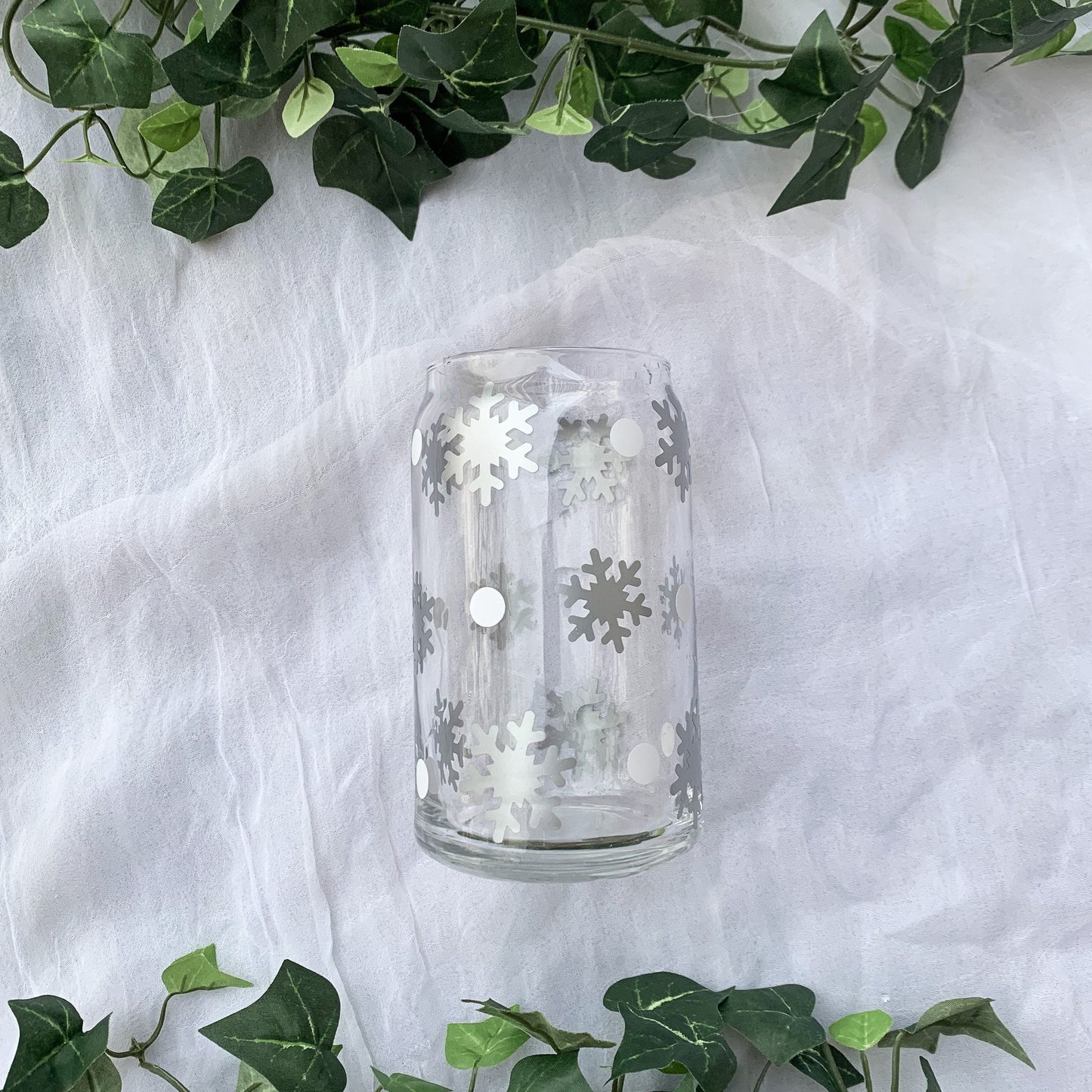 Glass with large silver snowflakes and small white dots totally surrounding the cup.