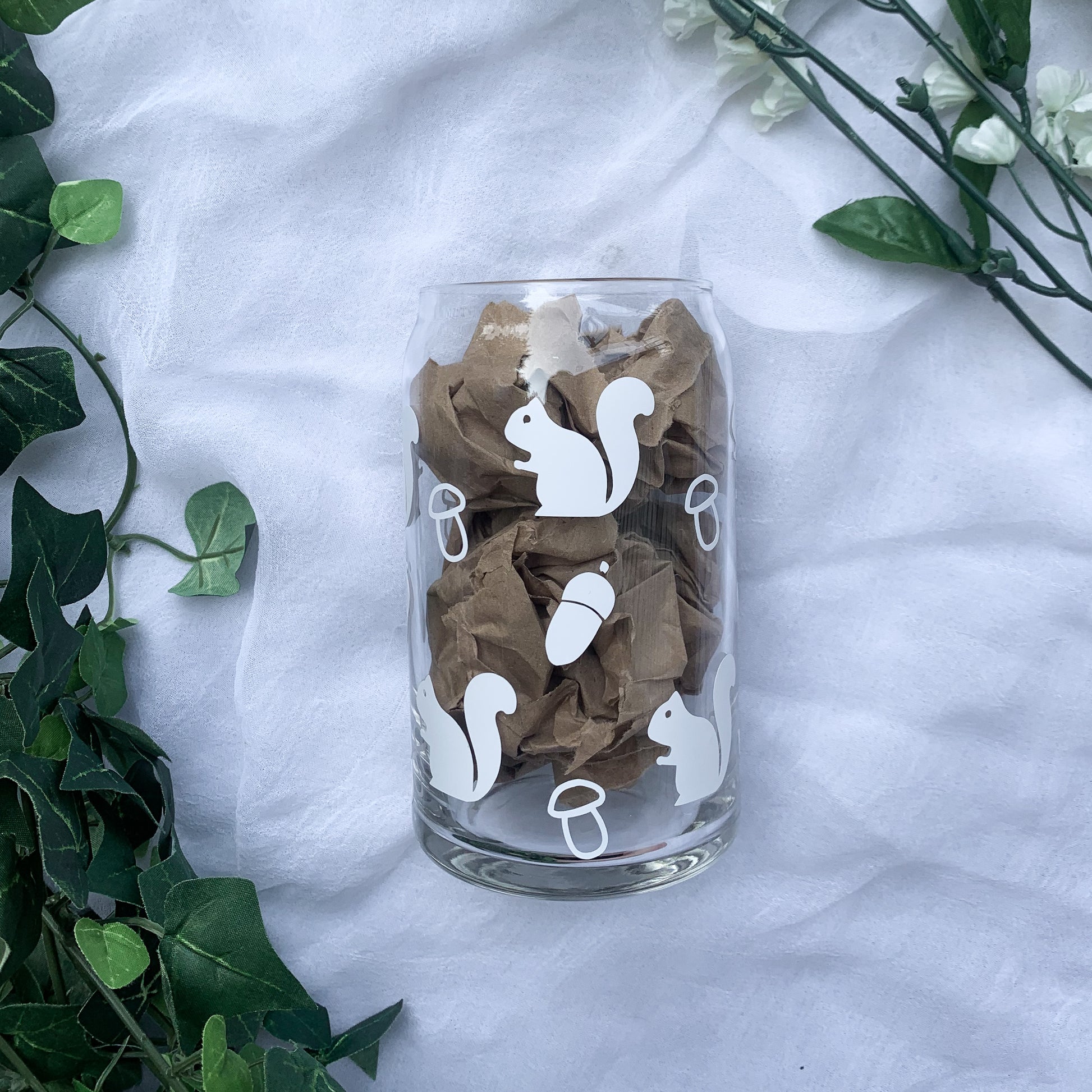 Clear glass cup with squirrels, mushrooms, and acorns.