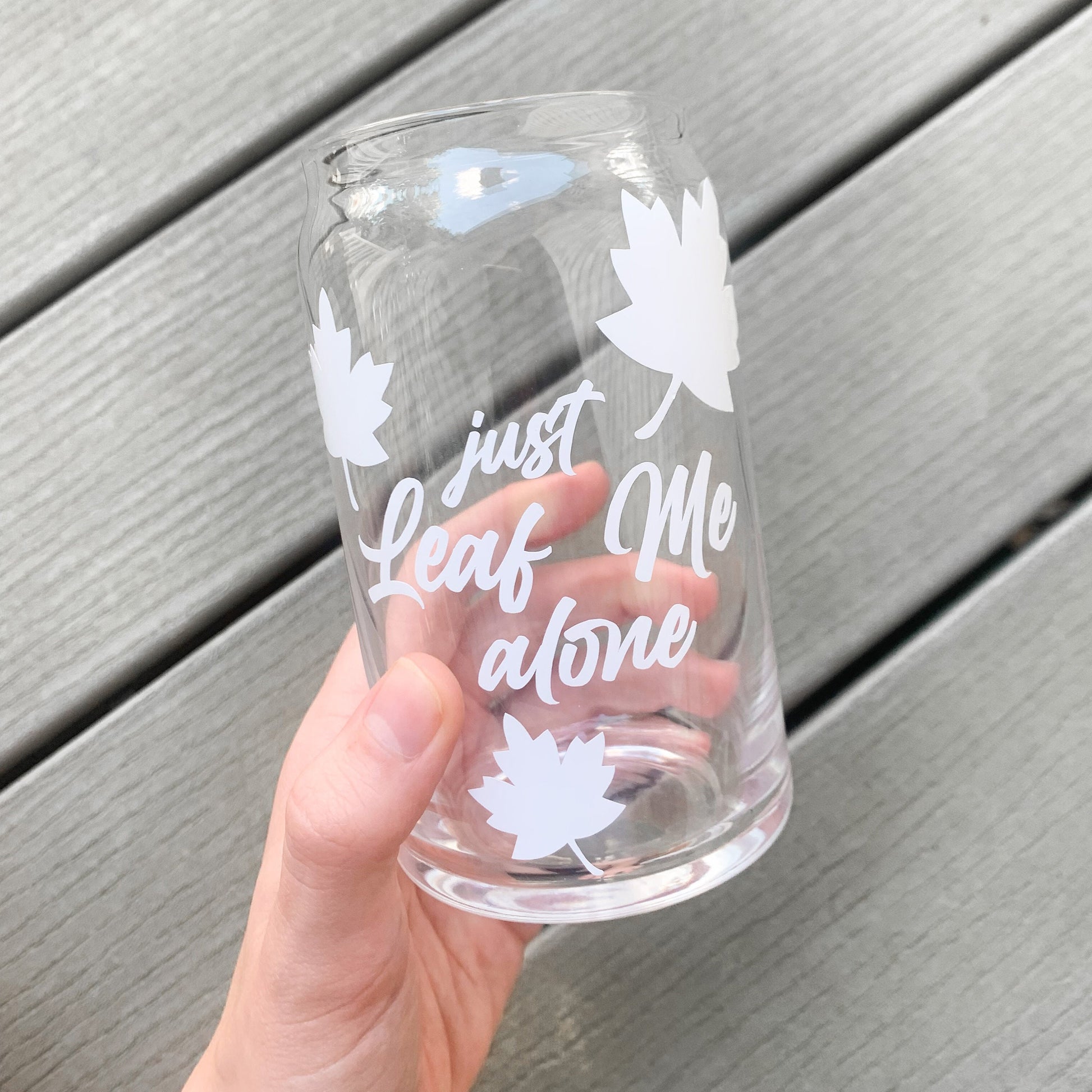 Funny introvert glass cup being held over a neutral background.